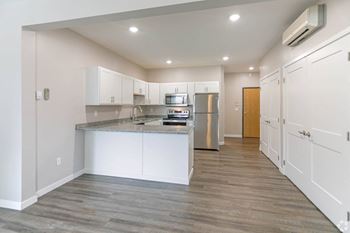 A kitchen with white cabinets and gray countertops